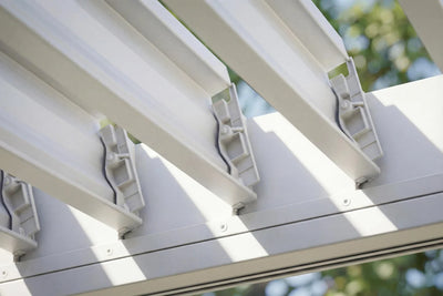 Close-up of a white pergola structure with wooden slats.